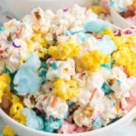 A bowl of colorful popcorn with sprinkles.