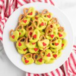 Grinch pretzels on a white plate.