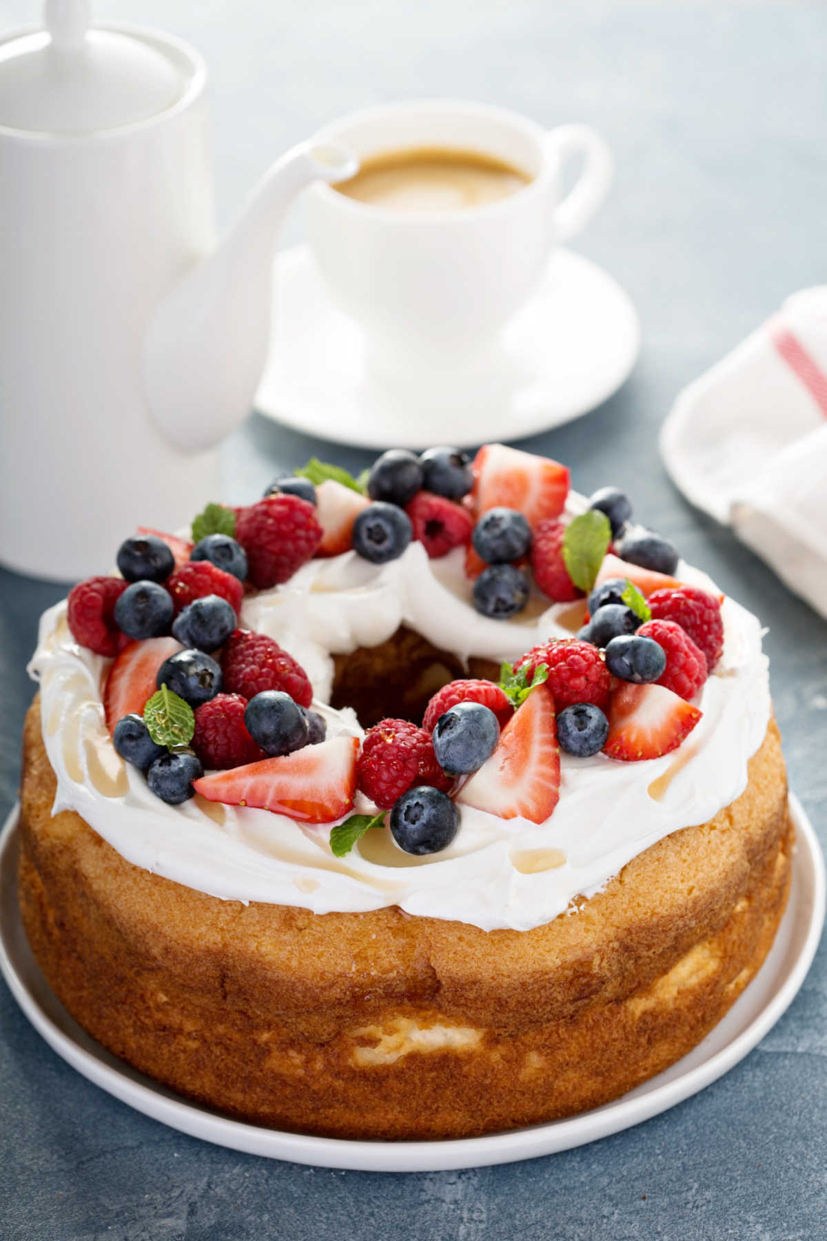 Angel food cake on a platter with fresh fruit. 