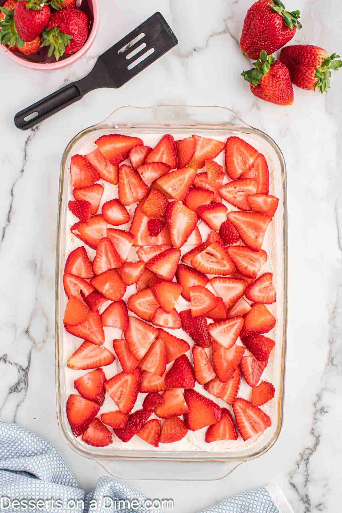Strawberries sliced on top of cake. 