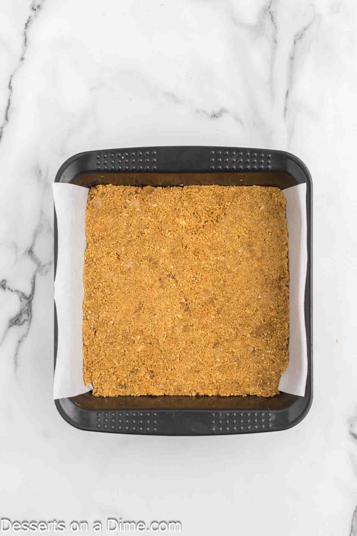 Graham cracker crumbs pressed into baking dish. 