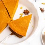 Pumpkin pie with slices on a plate.