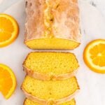 Slices of orange pound cake on a white marble platter.