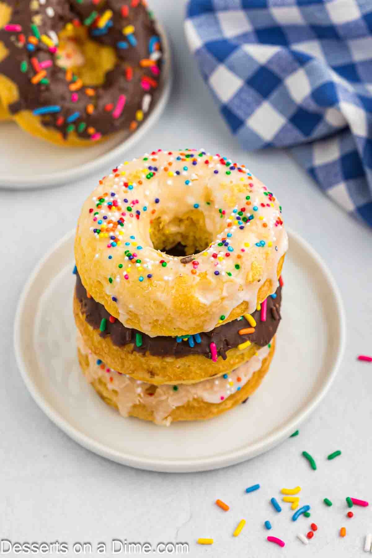 Cake Donuts with sprinkles stacked on a plate.
