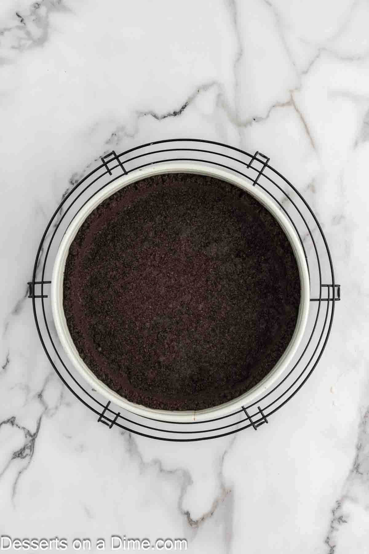 Placing crushed Oreo crust in pan