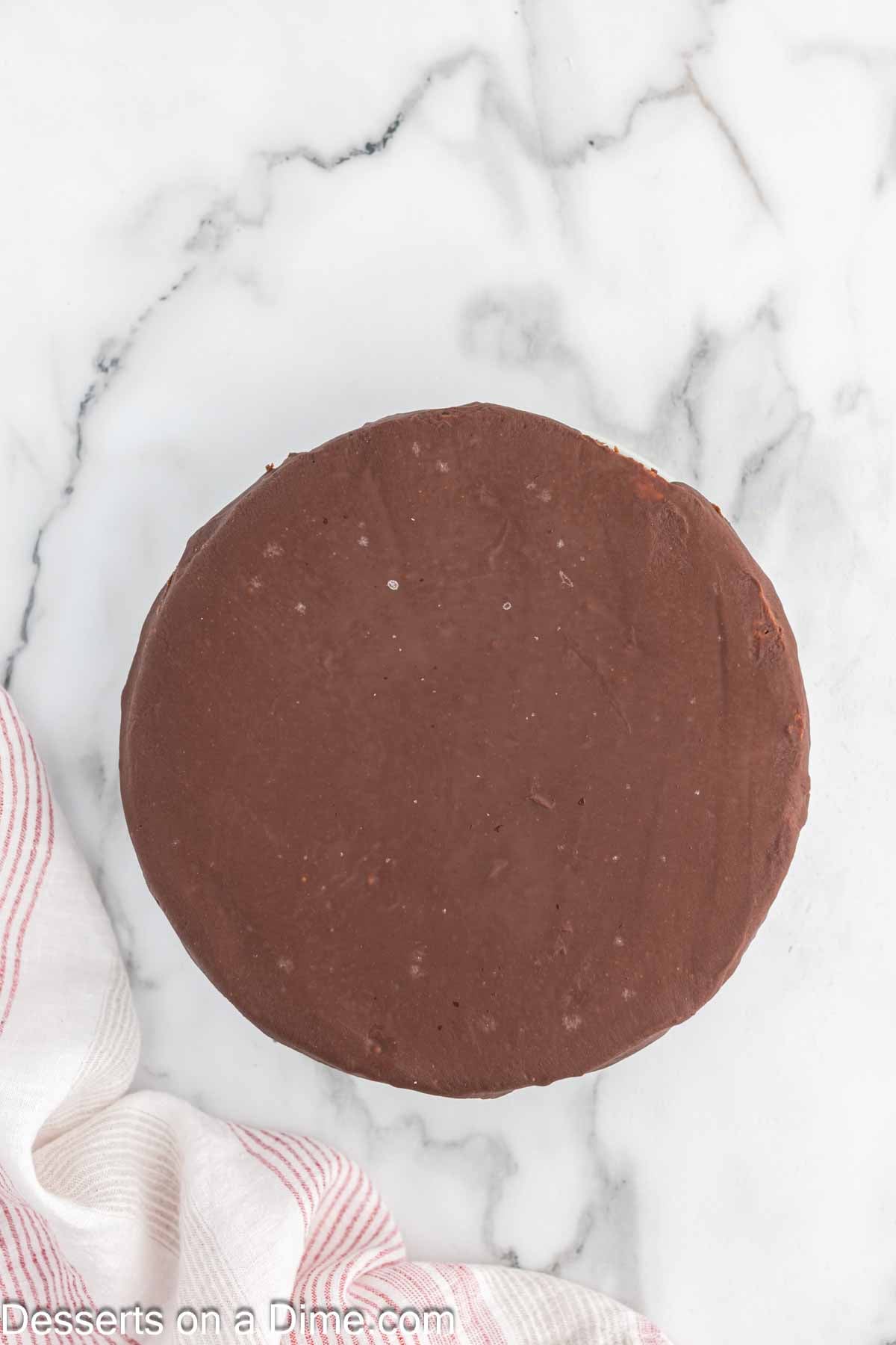 Pouring the nutella glaze over the cheesecake
