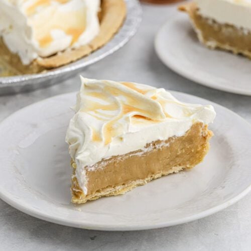 A slice of pie with whipped cream on top.