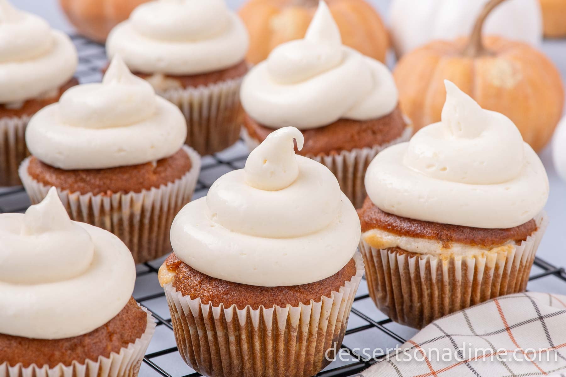 Pumpkin Cheesecake Cupcakes on a wire rack ready to serve.