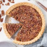 A pecan pie with a slice cut out.