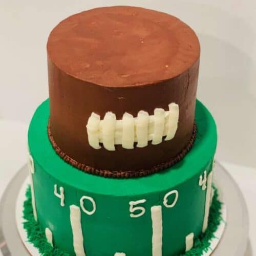 tiered football cake on a pedestal.