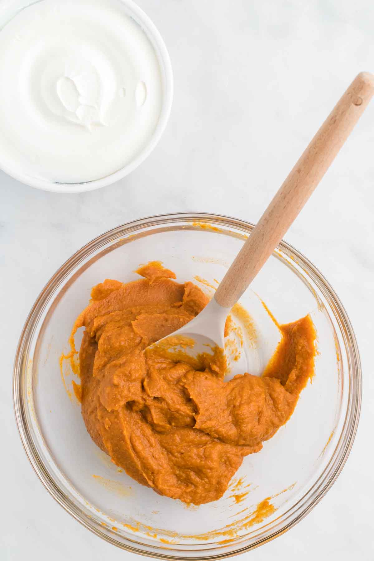 Pumpkin puree in a mixing bowl combined with pudding and milk. 