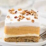 A slice of pumpkin cheesecake on a white plate.