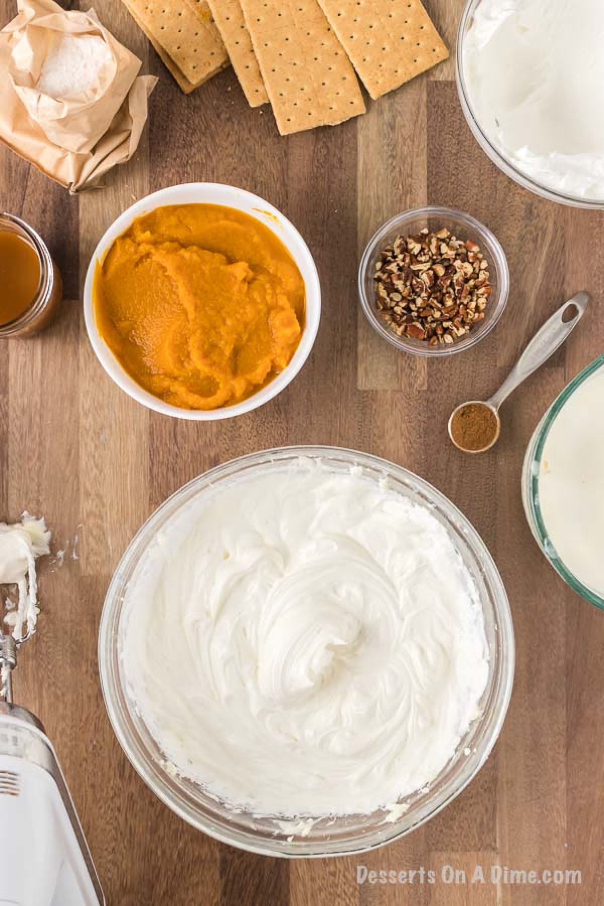 The cool whip being added to the cream cheese mixture in a large mixing bowl.  