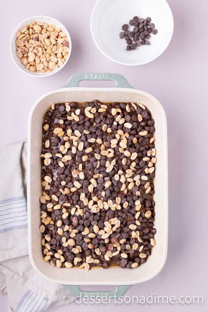 Chocolate chips and peanuts on top of cake.