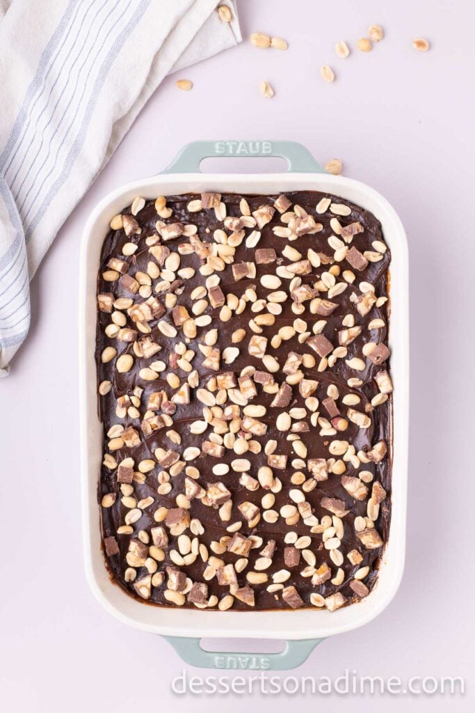 Chopped peanuts and crushed snickers on cake.