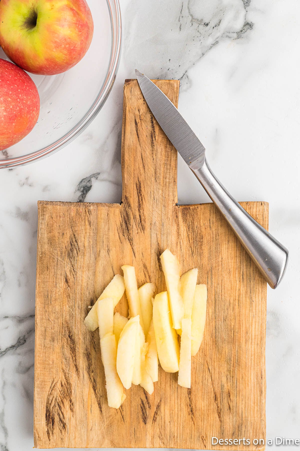 Apples cut into slices on cutting board. 