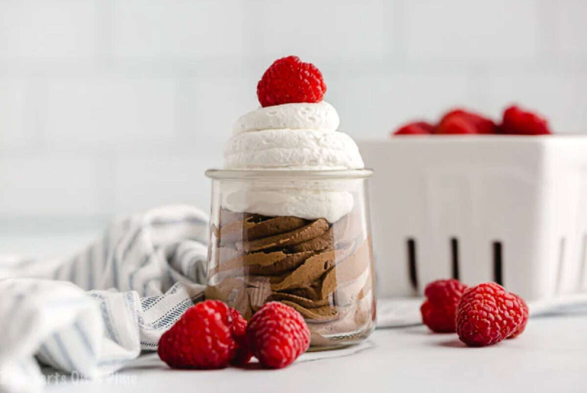 Keto chocolate mousse is ready in only 5 minutes for the perfect Keto friendly dessert in minutes. Make this for a decadent treat you can enjoy in minutes. Keto Chocolate Mousse in a jar with raspberries.