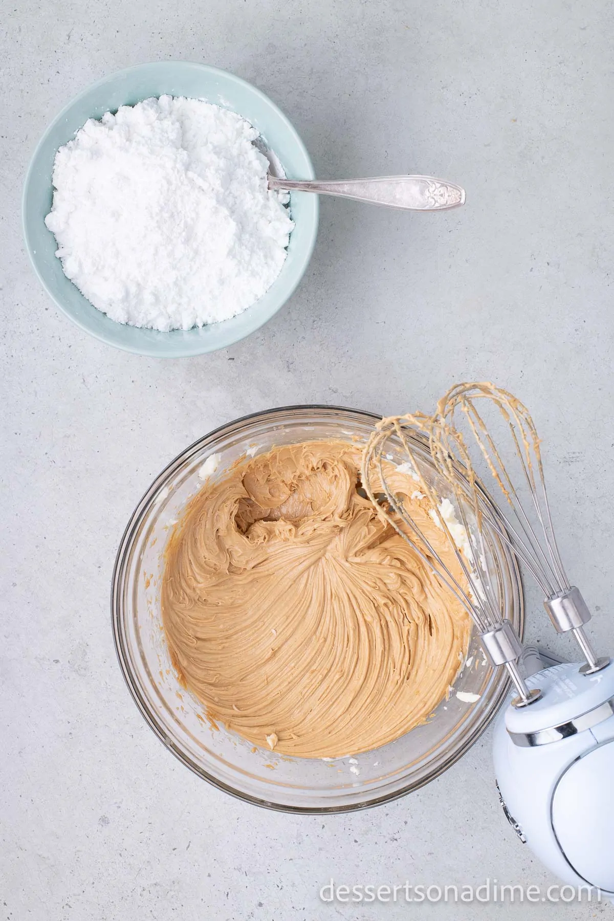 Powdered sugar added to peanut butter mixture in bowl.