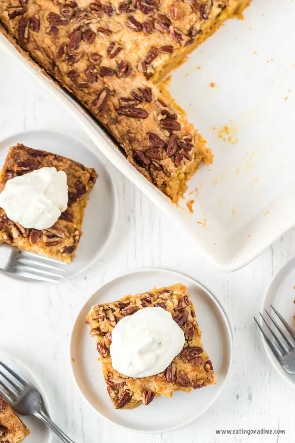 A serving of pumpkin dump cake on a white plate. With the pump dump cake on a pan 
