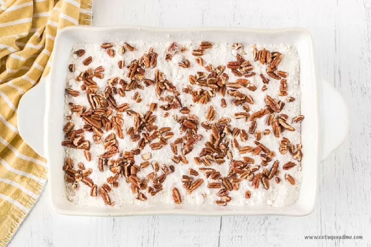 Cake mix spread on pumpkin batter and nuts sprinkled on top. 