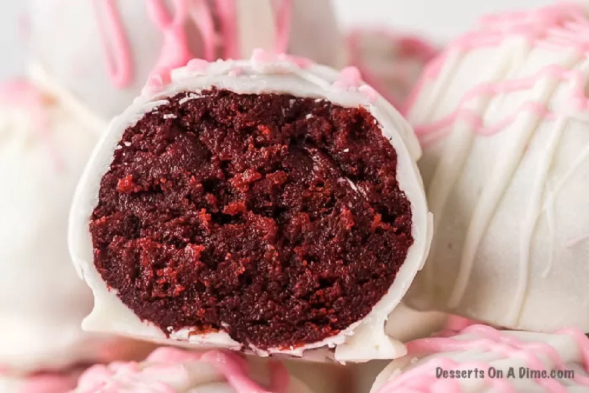 Red velvet cake balls with cream cheese dipped in white chocolate make an irresistible dessert. Bite size treats are so fun and this recipe for Red velvet cake balls does not disappoint. Try no bake red velvet truffles for Christmas, Valentines Day and more. Make this easy red velvet cake balls recipe for a delicious dessert. #dessertonadime #redvelvetcakeballs #Withcreamcheesewhitechocolate #EasyNoBake #redvelvetcakeballseasy #ChocolateCovered Red Velvet Cake Balls decorated