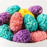 Easter Egg Rice Krispie treats stacked together in a white bowl.