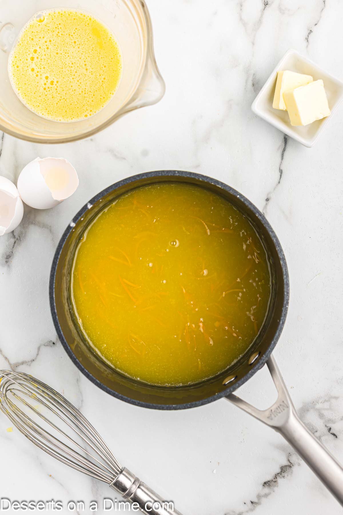 Saucepan with orange juice added to mixture.