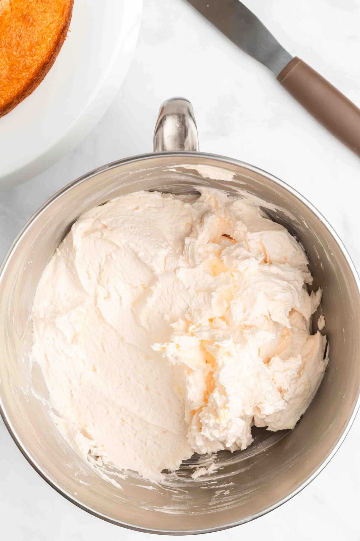 Mixer bowl with icing ingredients being combined. 