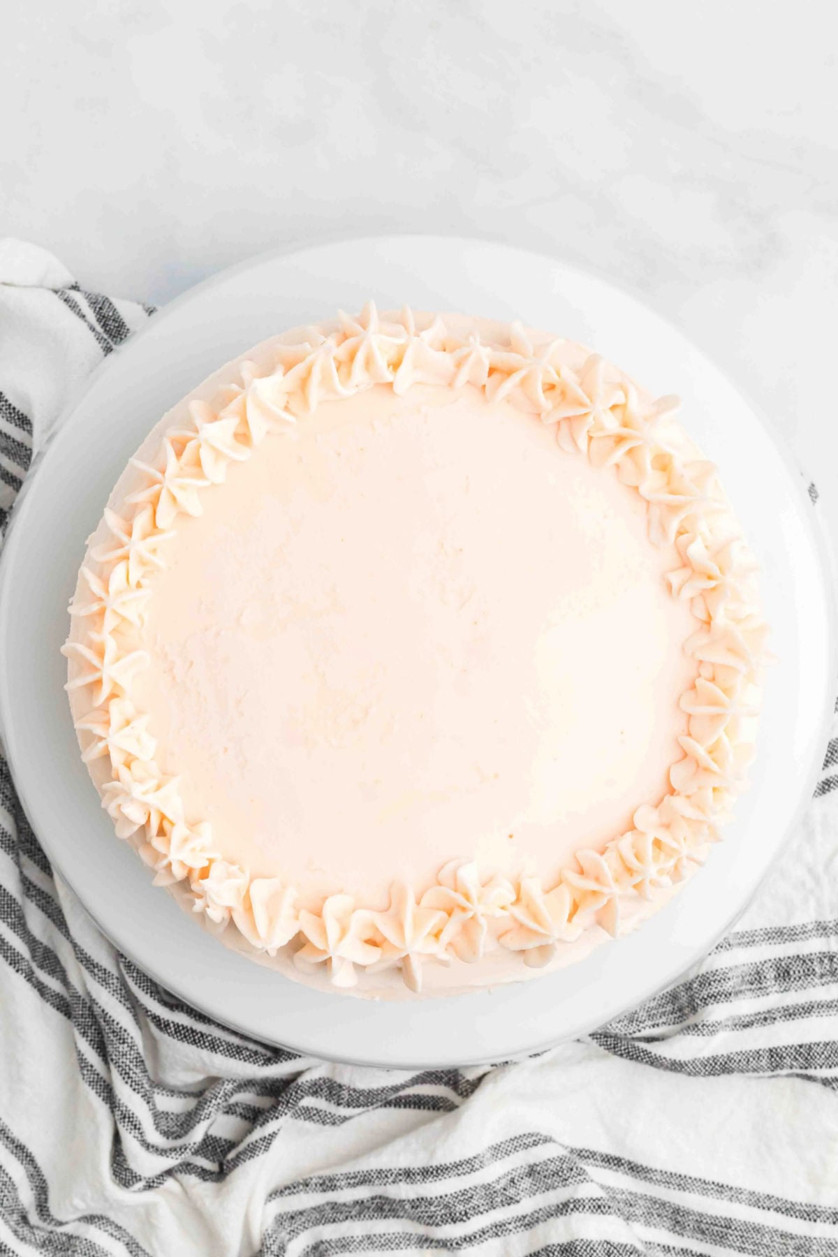 Cake on platter with frosting swirls. 