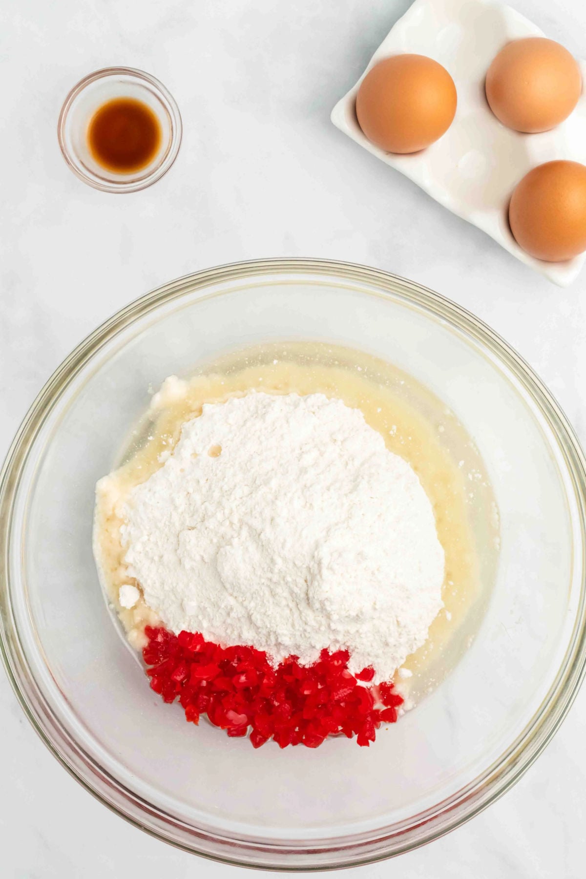 Mixing bowl with cherries, cake mix and wet ingredients. 