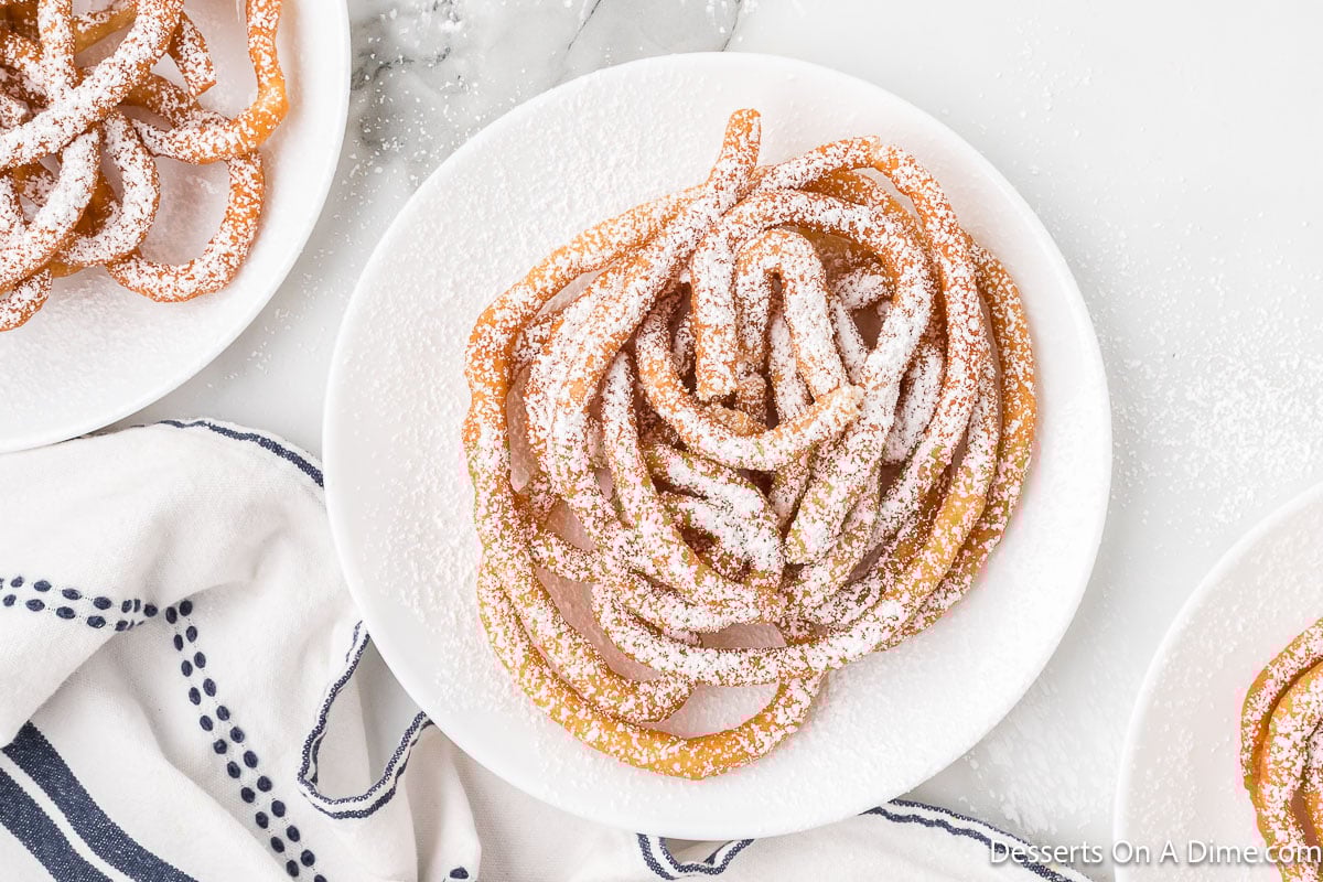 Funnel cakes with pancake mix on a white plate.
