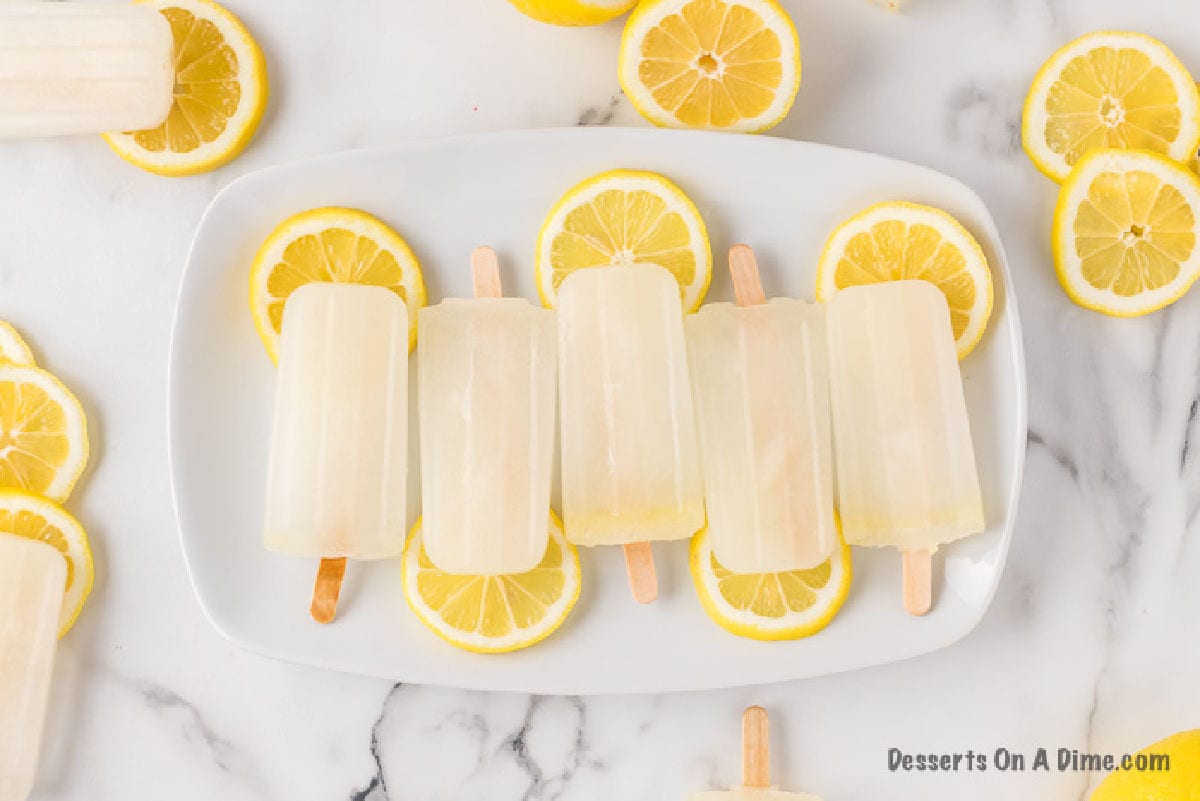 Lemon Popsicles arranged on a white platter.