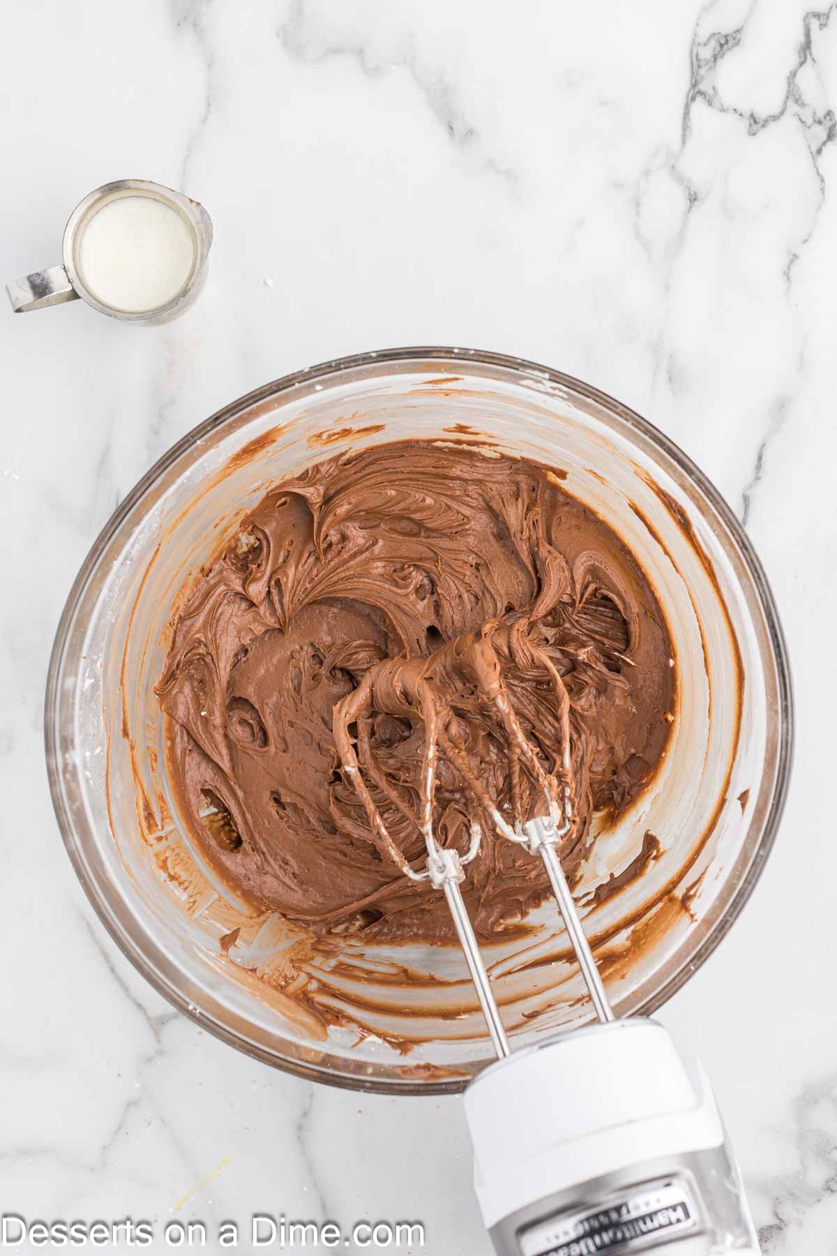 Powdered sugar, cocoa powder and heavy cream added to mixing bowl. 
