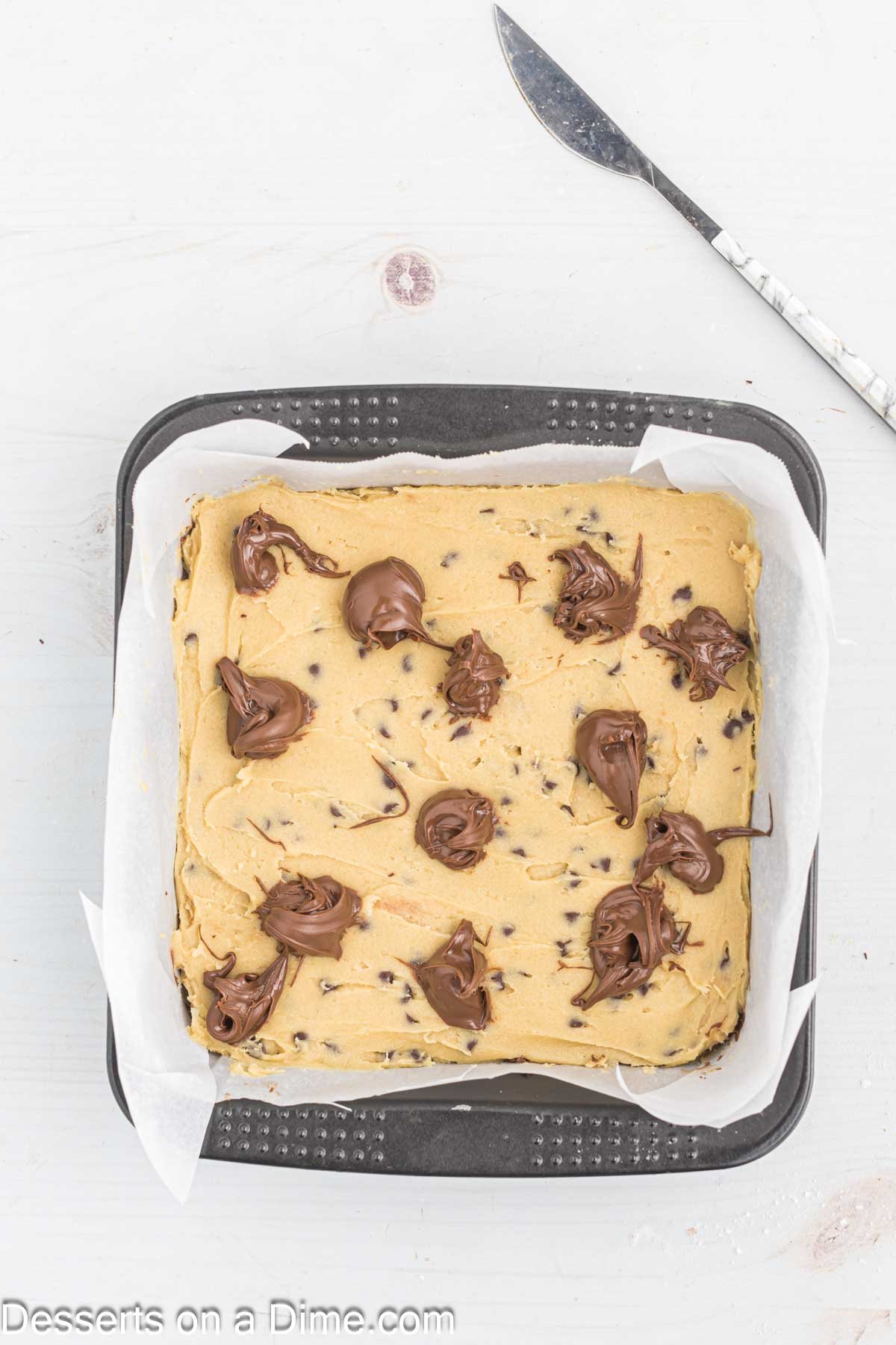 Nutella dolloped on top of cookie dough. 