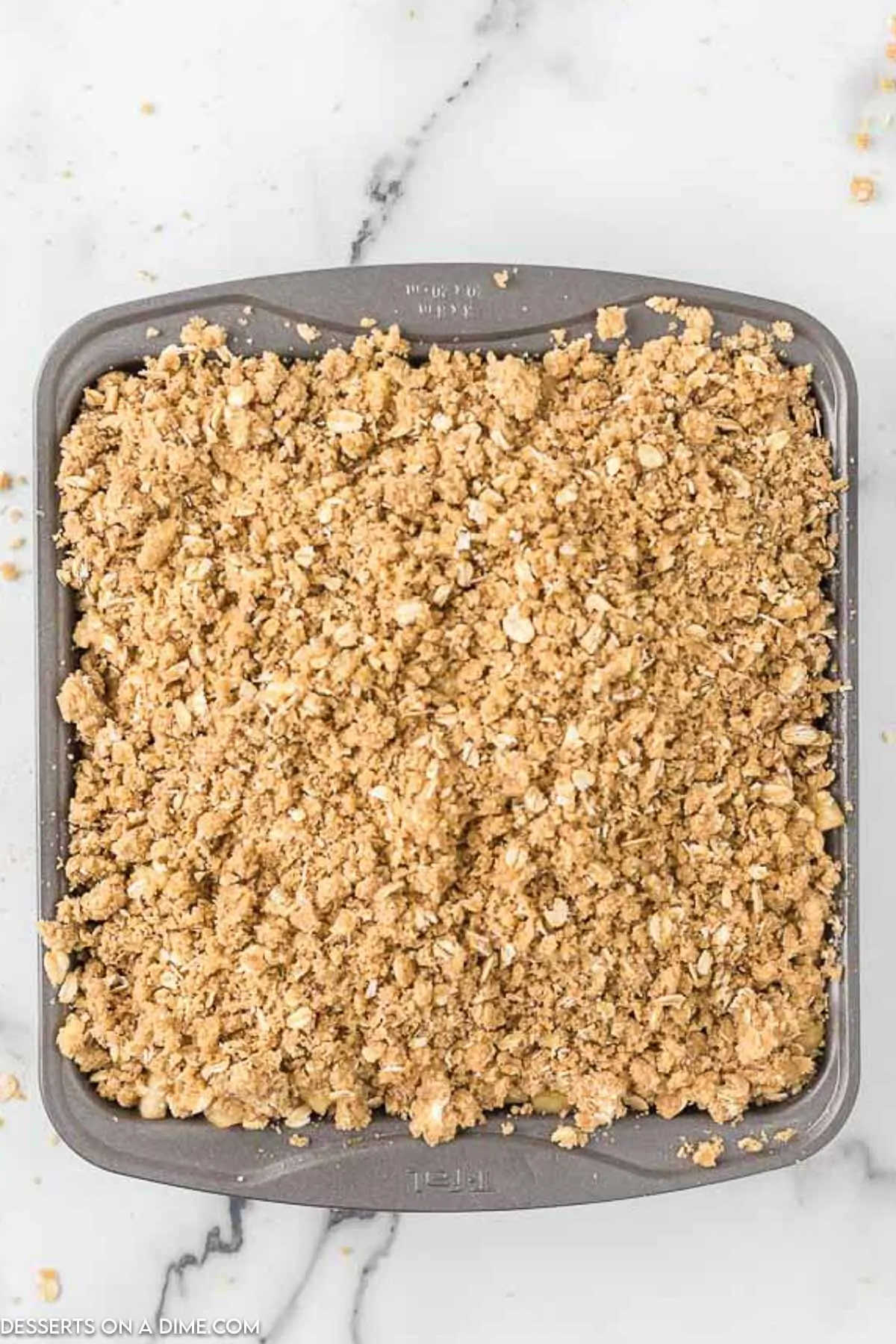 Topping sprinkled over apple mixture in pan. 