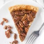 A slice of pecan pie on a plate with a fork.
