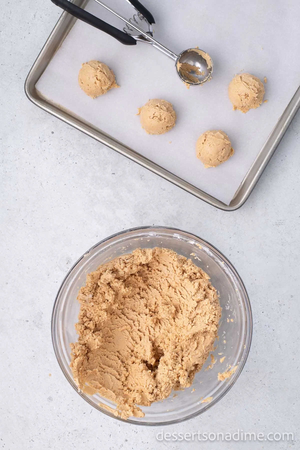 Cookie scoop placing balls on the baking sheet.