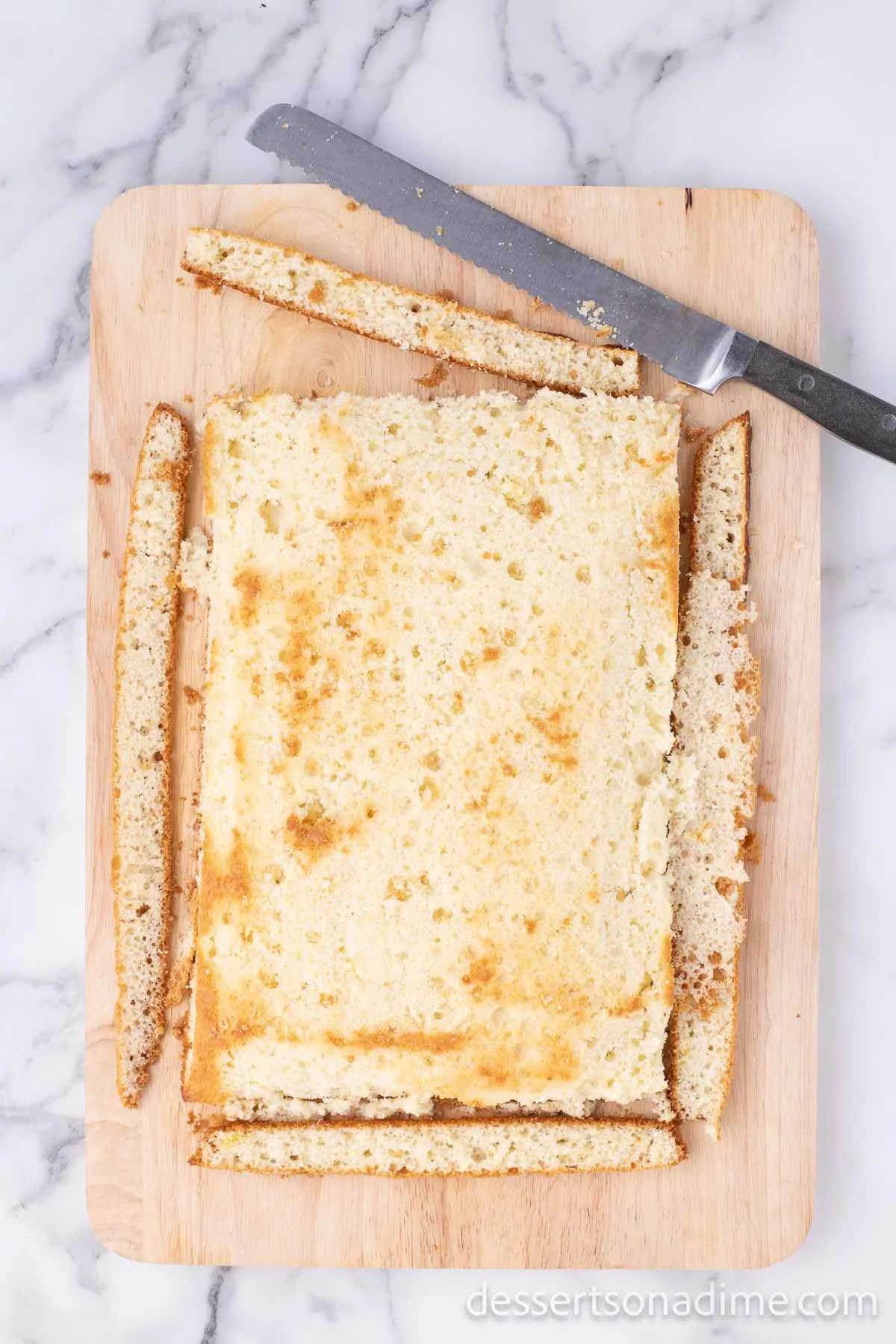 Cake on cutting board with outer coating discarded. 