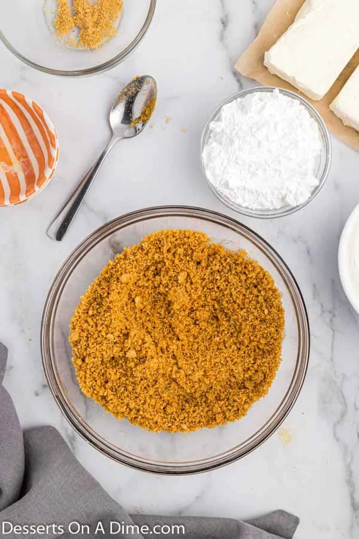 Graham cracker crumbs and butter combined in a bowl.