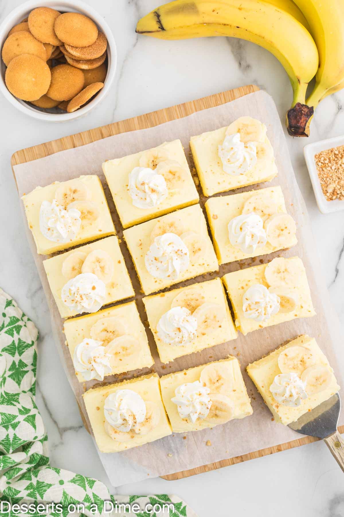Banana Cream Cheesecake Bars cut into squares and topped with whipped cream. 