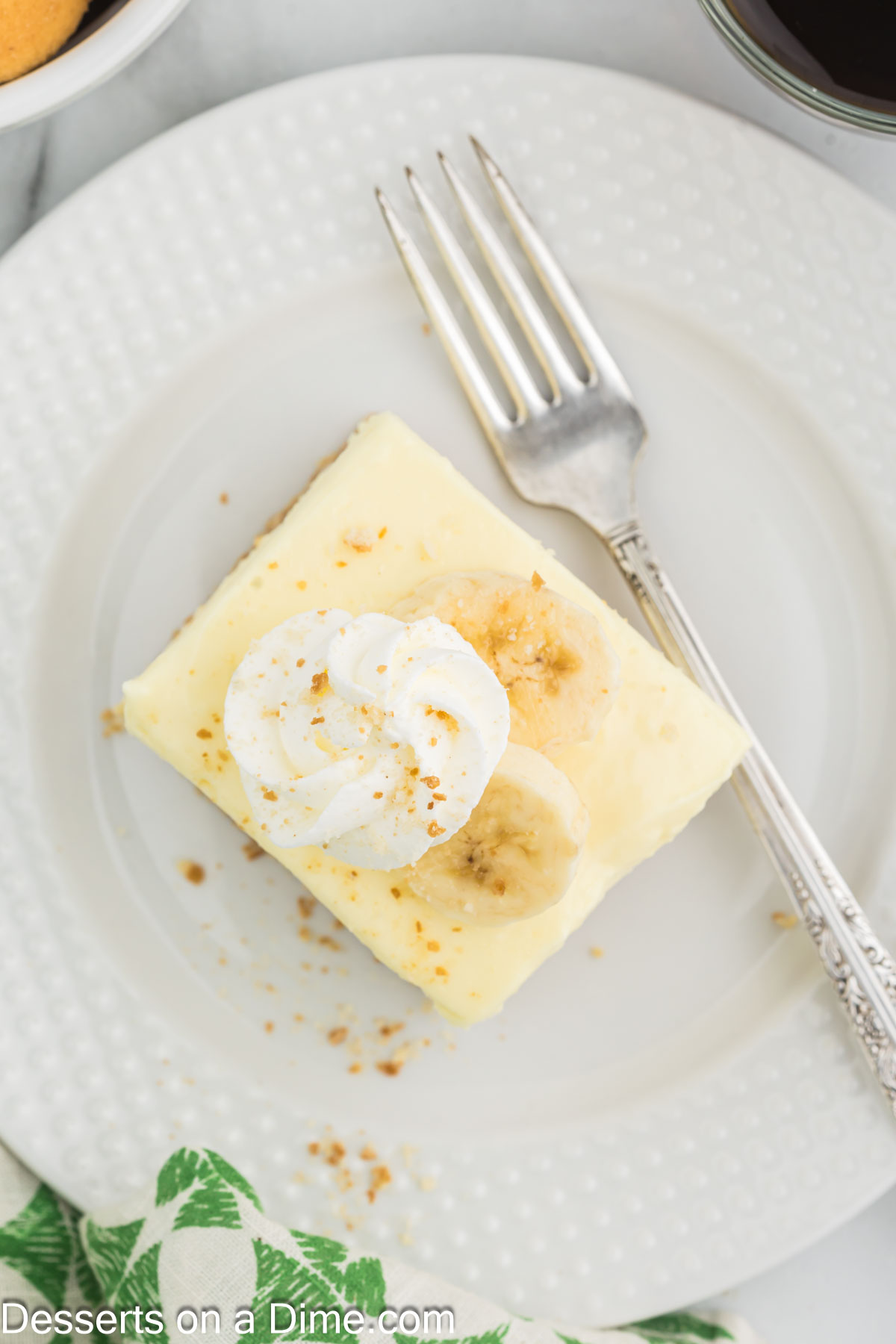 Banana Cream Cheese Bars cut into squares on a plate. 