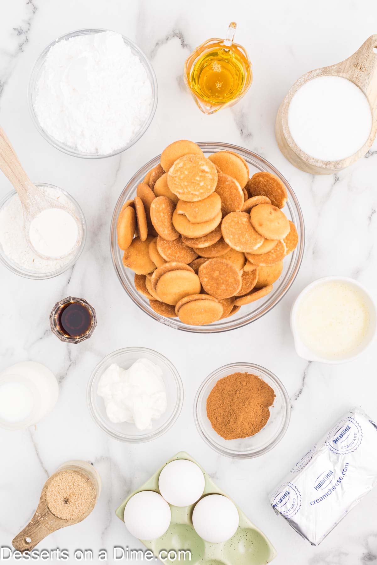 Ingredients for Honey Bun Cheesecake - vanilla wafers, butter, ground cinnamon, cream cheese, eggs, sour cream, honey, vanilla extract, flour, brown sugar, powdered sugar, milk. 