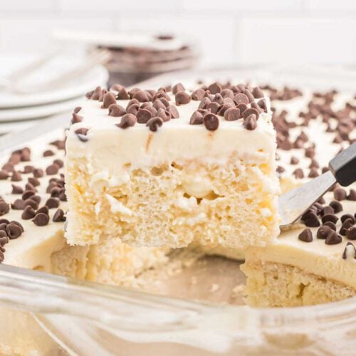 Cannoli poke cake cut into squares.