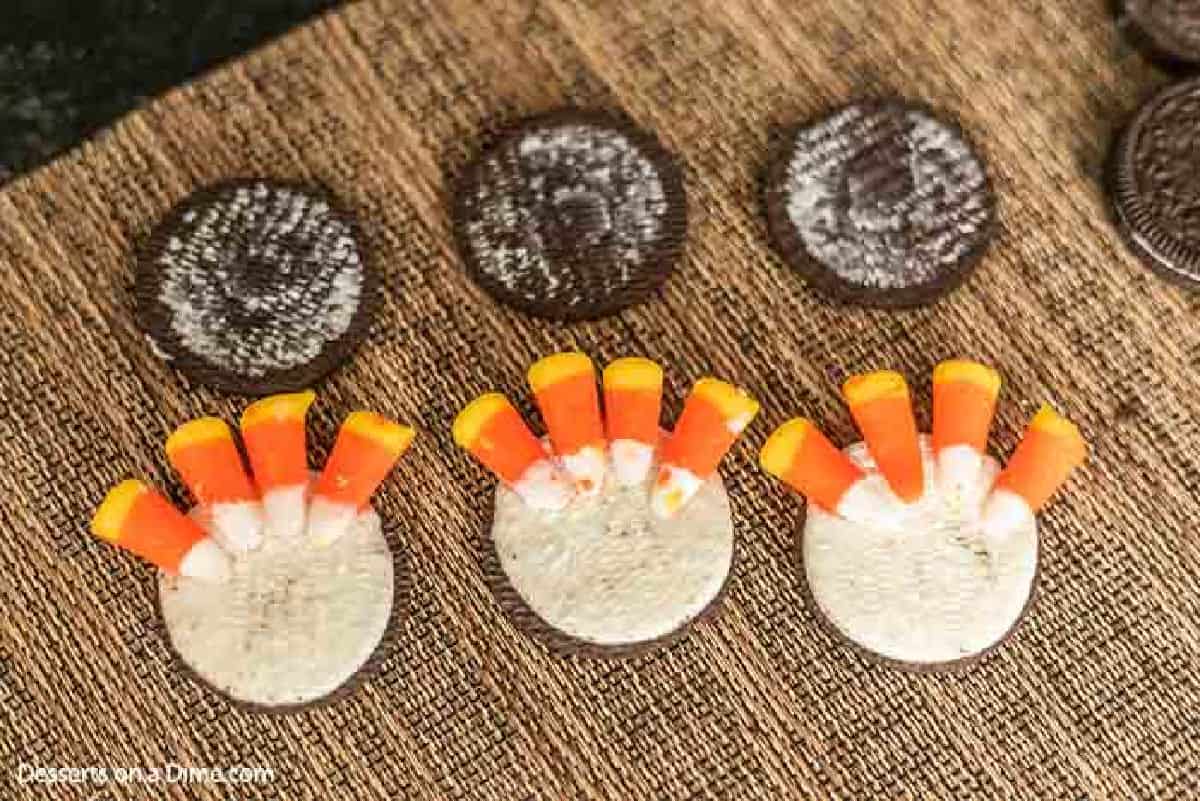 Oreos untwisted and candy corn placed on top of cream. 