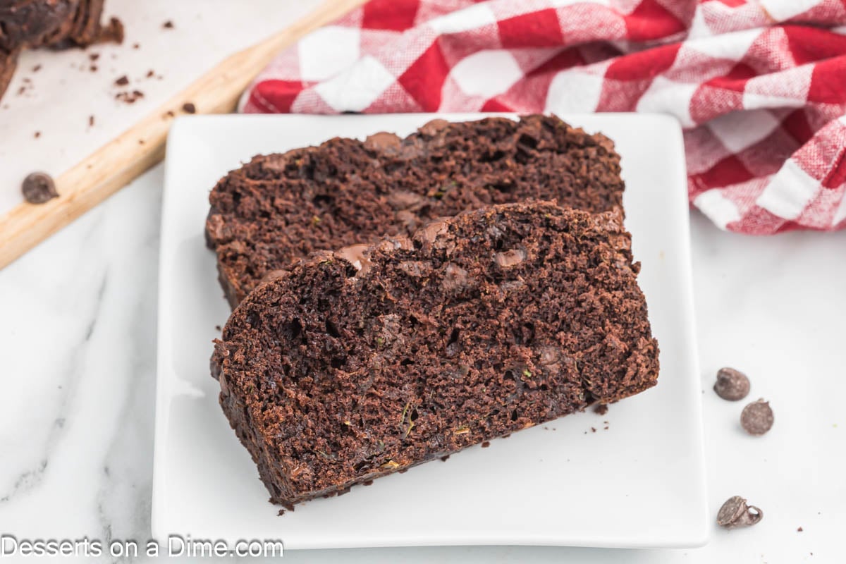 Slices of chocolate zucchini bread on a white plate.