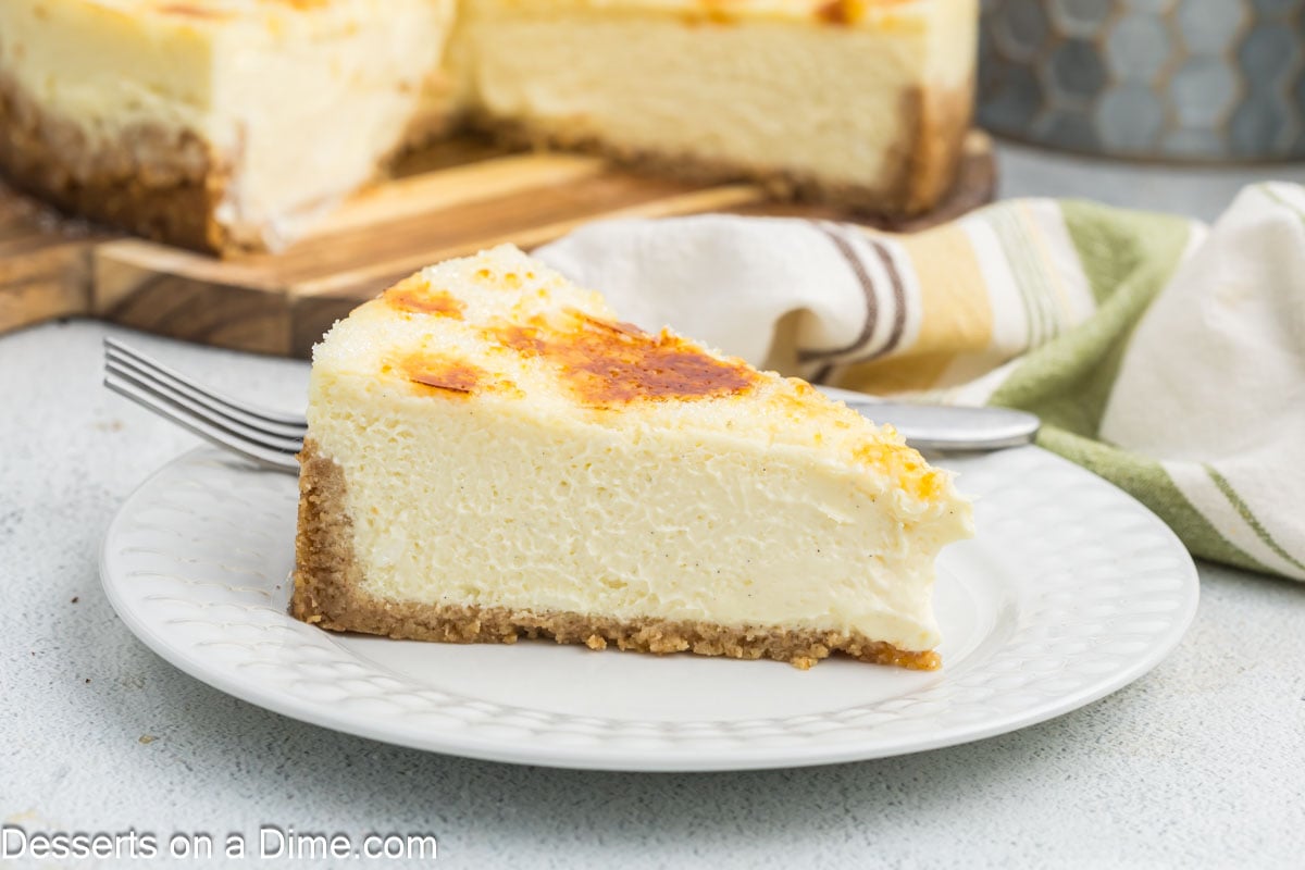 Cheesecake Brulee sliced on a white plate beside a fork.