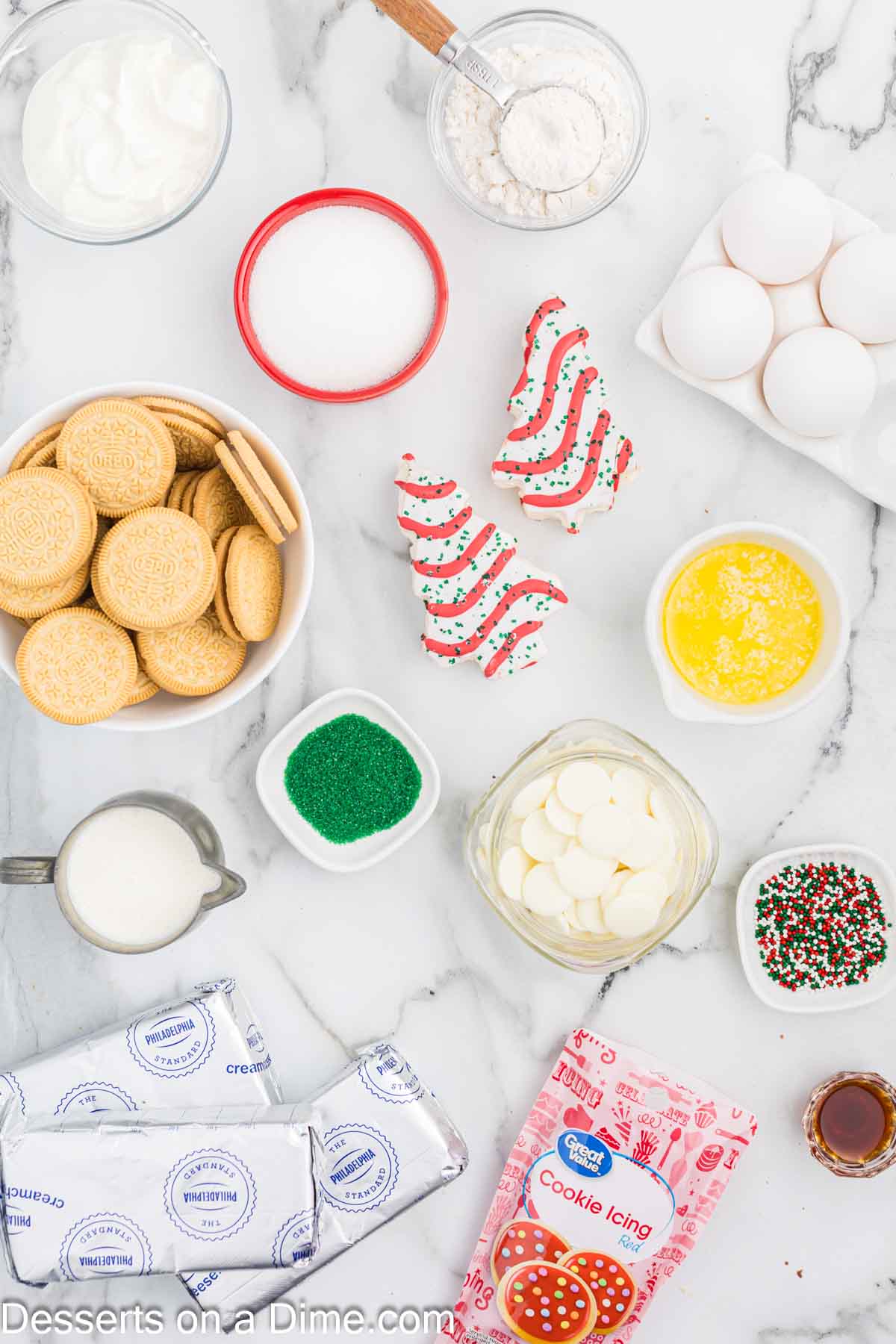Ingredients for Little Debbie Cheesecake - Golden Oreo Cookies, butter, Christmas sprinkles, cream cheese, sugar, vanilla, sour cream, eggs, Christmas tree cakes, white baking chocolate, heavy whipping cream. 