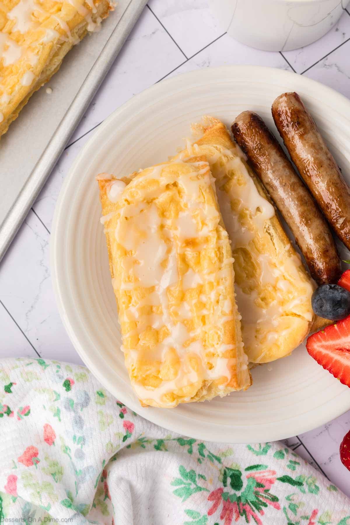 Cream Cheese Danish on plate with sausage and fruit. 