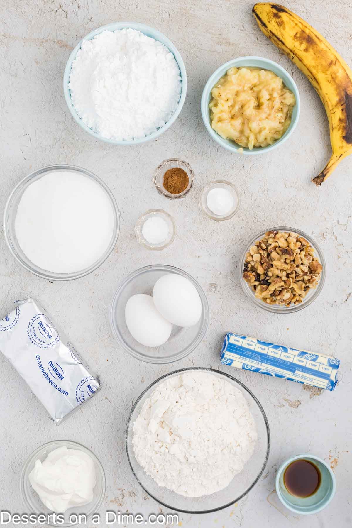 Ingredients for banana bars - flour, cinnamon, baking soda, salt, butter, sugar, eggs, sour cream, bananas, walnuts, cream cheese, vanilla, powdered sugar. 