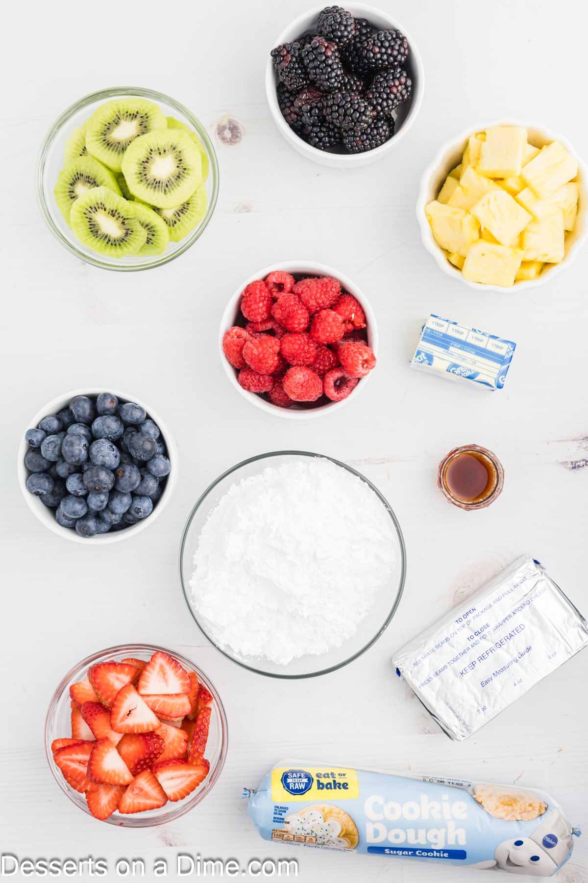 Ingredients for fruit pizza - cookie dough crust, cream cheese, butter, vanilla, powdered sugar, fruit.
